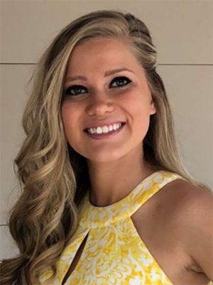 Smiling woman with blonde hair wearing a yellow top.