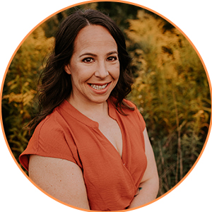 Smiling woman outdoors with autumn foliage background.